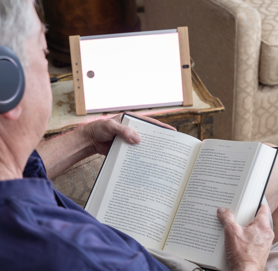 Mand sidder og læser foran et lysapparat. Foto: OptoCeutics