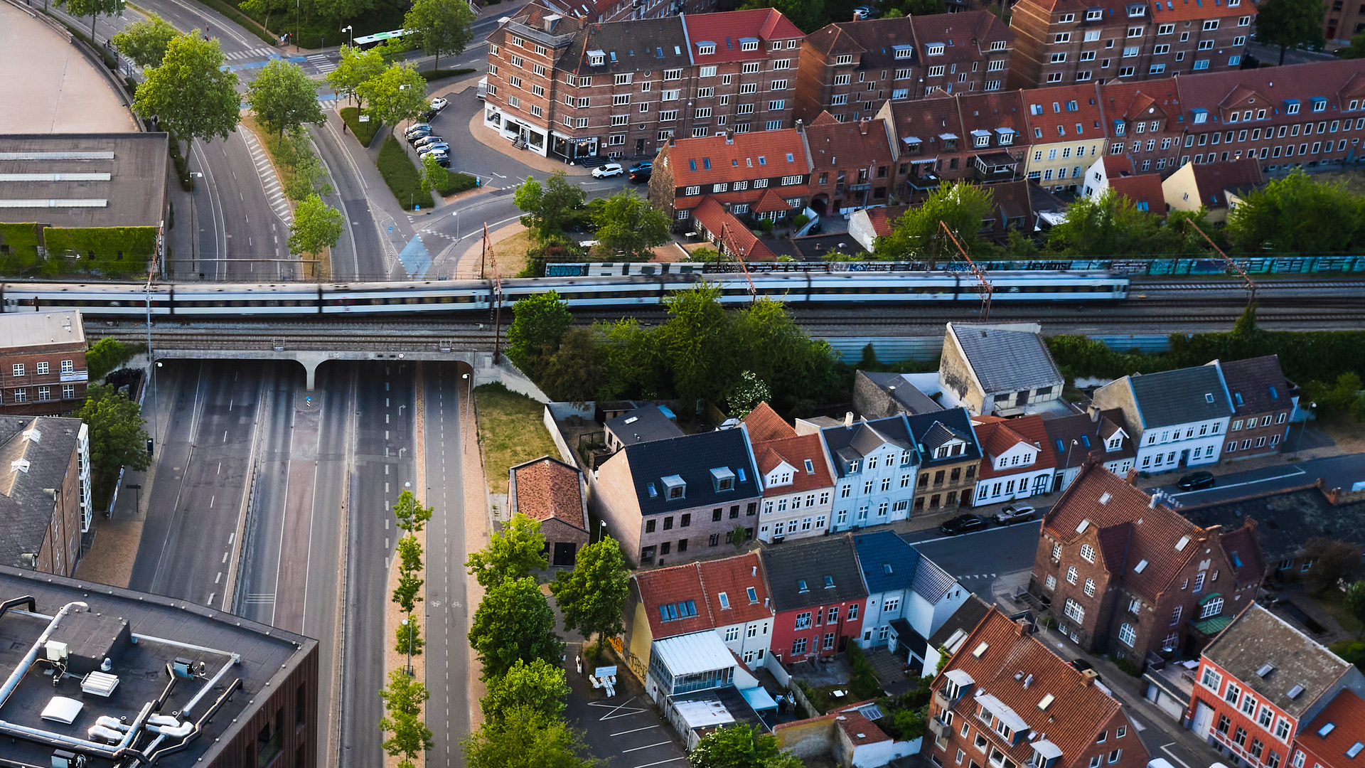Luftfoto af byområde med huse, veje og jernbane