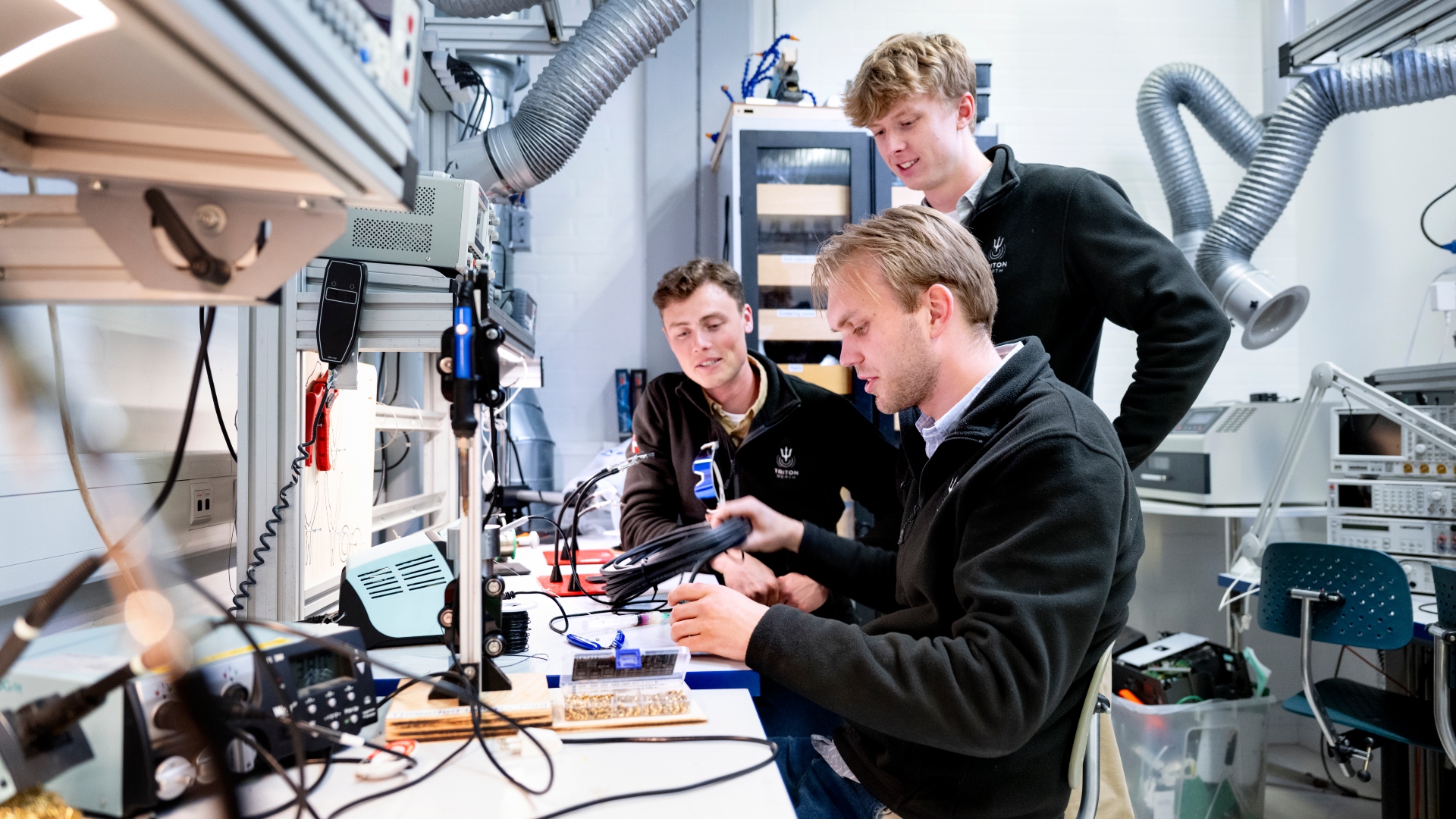 Markus Rytter, Carl Borg og Frederik Himmer arbejder på deres enhed i DTU Skylabs ellaboratorium